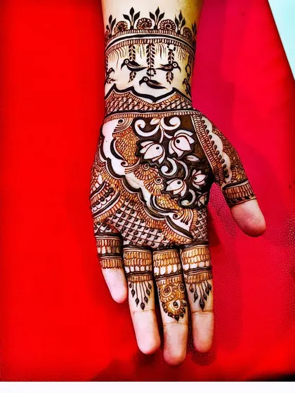 This design features delicate bird motifs hanging from the wristband pattern. It's these small, unique details that can make a mehndi design truly special and personalized.