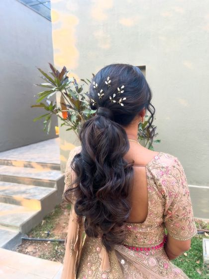 A close-up of the low ponytail with its delicate accessories, a perfect example of modern bridal elegance.