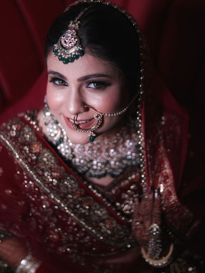 A smiling bride is the most beautiful bride. This upward shot captures her happiness and the flawless details of her makeup, from the sharp winged eyeliner to the perfectly placed bindi and nath.