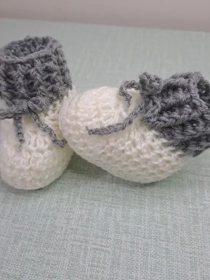 A side view of the grey and white booties, showing the textured stitch on the cuff.