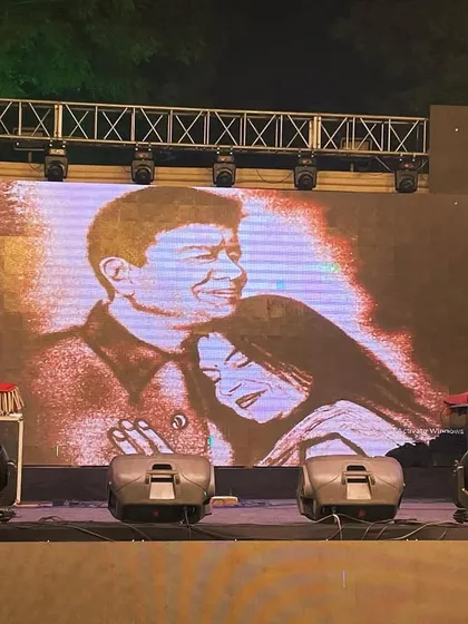 The final frame of a 25th-anniversary sand art story, projected on the big screen. This image of the couple is a touching finale to their live-drawn love story.