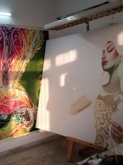 A glimpse of two paintings side-by-side in my studio. On the right, a new piece is just beginning with a pencil sketch on canvas, while another completed work hangs nearby.
