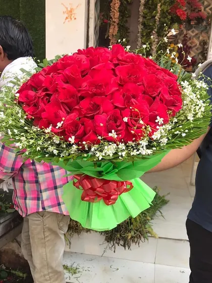 This extra-large red rose bouquet is guaranteed to impress. It's being prepared right at my shop in the Ghaziabad flower market, ensuring it's absolutely fresh.