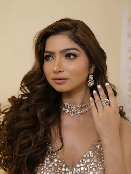 A side profile highlighting the flawless makeup and the beautiful diamond jewelry.