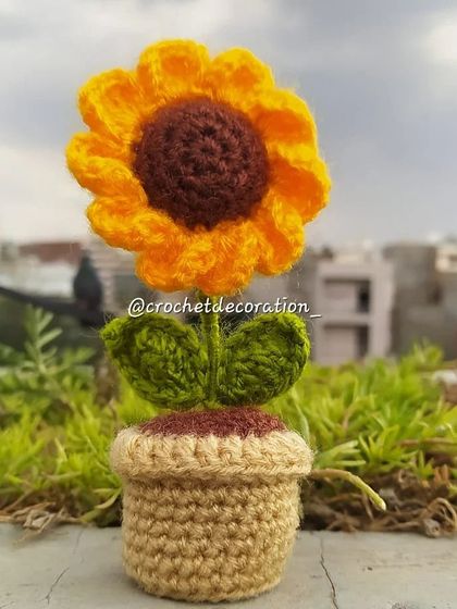 A mini sunflower pot against a city backdrop, showing how it can bring nature anywhere.
