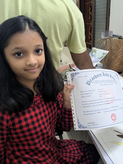 A proud moment for this young student as she receives her certificate from Pracheen Kala Kendra, recognizing her hard work and successful completion of her course level.