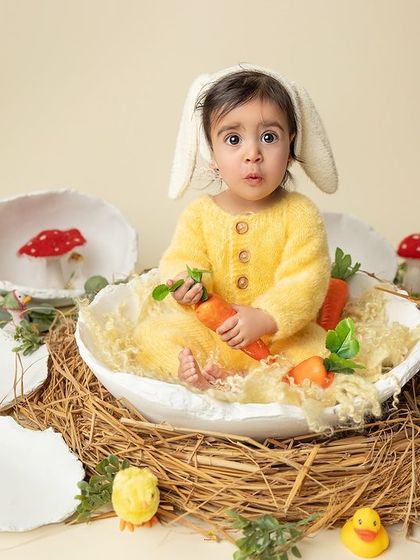 A curious little bunny exploring her nest. The whimsical props, like the oversized eggshells and tiny mushrooms, add a magical, storybook feel to this portrait.