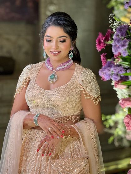 A beautiful portrait of the bride, her makeup looking soft and romantic, perfectly complementing her designer outfit.