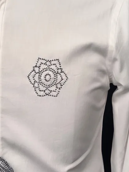 A close-up of the geometric floral motif embroidered on the chest of my abstract figure shirt. This detail adds a touch of subtle, artistic flair.