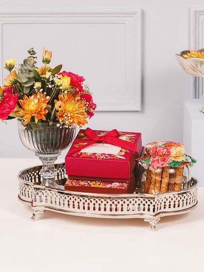 Celebrate Diwali with a touch of sweetness. Our small Majestic Tray is a handcrafted gift filled with treats and flowers, perfect for brightening someone's day.
