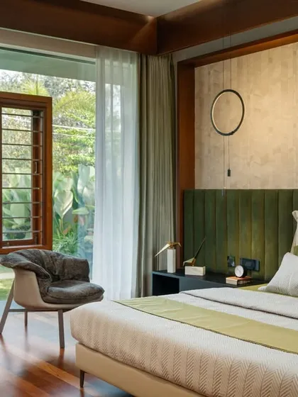 A bedroom in the Long House designed for tranquility and connection. Large windows frame views of the garden, while a palette of natural materials and textures creates a calm, uncluttered retreat that brings the peacefulness of the outdoors inside.