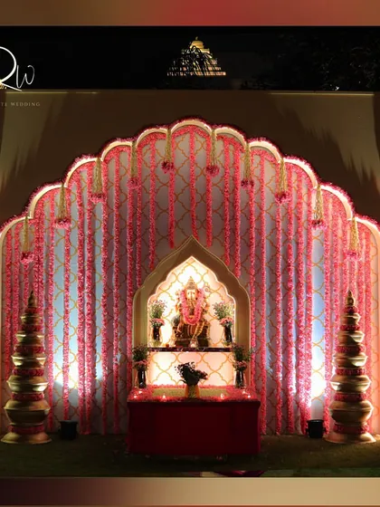 A traditional setup with a Ganesha idol, surrounded by pink floral garlands. This is a beautiful way to incorporate blessings into the decor.