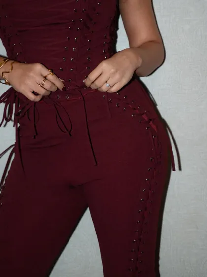 A focus on the craftsmanship. This shot highlights the intricate lace-up detailing on the custom maroon jumpsuit created by Seraphine Design Studio for Dhvani Bhanushali.