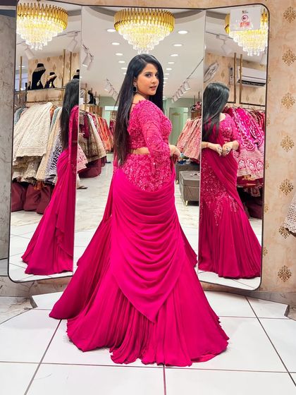 A side view of the magenta lehenga, showing off the intricate embroidery on the blouse and the flattering drape of the skirt.