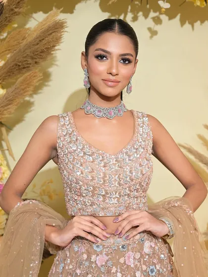 The full look is modern, chic, and powerful. The sleek ponytail and a pastel-colored lehenga create a beautiful contrast.
