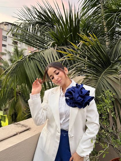A playful pose in my white blazer and blue trousers look. Fashion should be fun, and I love experimenting with different textures and silhouettes.