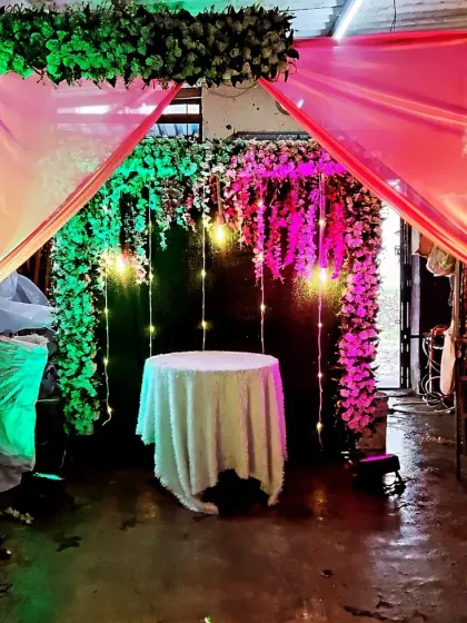 A beautiful floral canopy with hanging lights, perfect for a small Ganpati mandap or a cake-cutting ceremony at home.