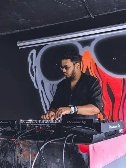 Here I am in my element, spinning at a club with some cool background art. I focus on reading the room and blending tracks seamlessly on my Pioneer DJ setup to keep the atmosphere just right.