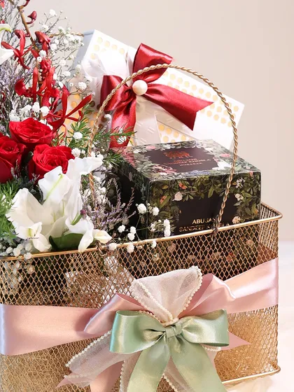 A different angle of the golden basket hamper for Mother's Day, showing the rich red and white floral arrangement and the elegantly wrapped gifts.
