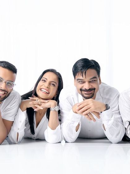 A fun and creative pose for a family with adult children. Lying on the floor with their heads propped on their hands, this shot is playful and shows the family's fun-loving personality.