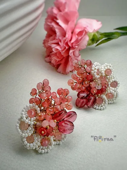 A rosy look for rosy styling. These red and pink earrings are designed with rose quartz and edged with white glass beads.