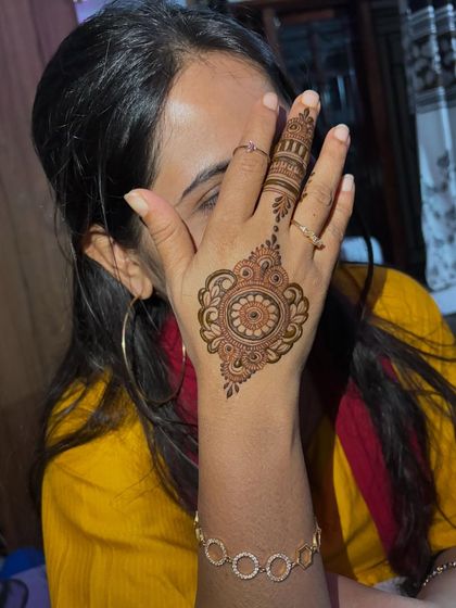 A simple and sweet mandala design on the back of the hand. It's a quick and beautiful way to adorn your hands for a party.