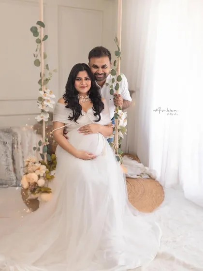 A joyful couple portrait on our decorated studio swing. The all-white theme with touches of greenery creates a fresh, clean, and romantic boho-chic vibe.