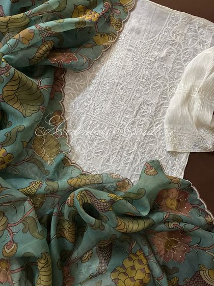 A flat-lay of the complete ensemble, showing the white Chikankari kurta, sleeve detail, and the beautifully draped Kalamkari dupatta.