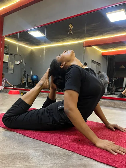 A student practicing Eka Pada Rajakapotasana (One-Legged King Pigeon Pose), a deep hip and back opener.