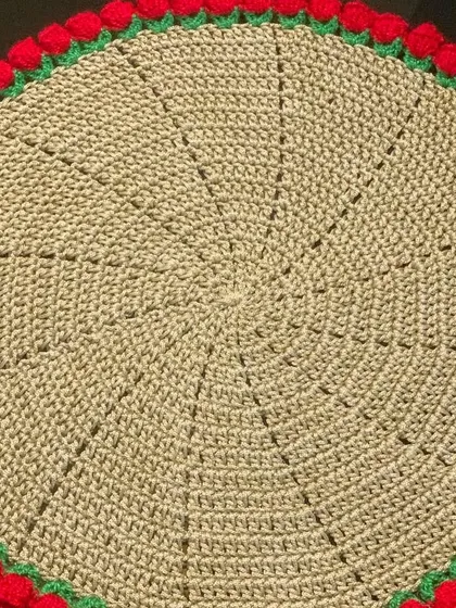 A beige doily with a red tulip border, a warm and inviting combination.