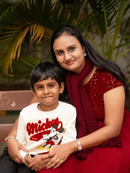 A sweet portrait of a mother and son on a park bench. The coordinated red outfits add a pop of color to this lovely outdoor photo.