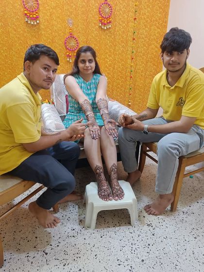 My team with a bride, showcasing her full bridal mehndi on hands and feet.
