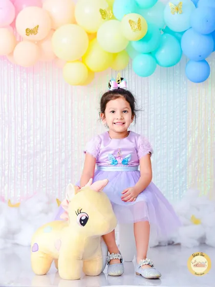 A sweet unicorn-themed fourth birthday portrait. We use soft pastel colors, fluffy clouds, and a friendly unicorn plushie to bring this enchanting theme to life.