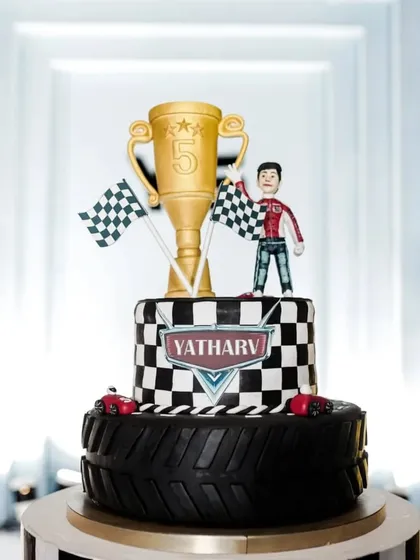 The centerpiece cake for a thrilling race car themed birthday. This multi-tiered cake features a checkered flag design, a trophy topper, and edible race cars, showcasing our attention to detail in creating themed desserts that wow guests.