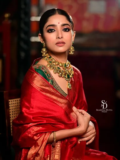 A seated portrait of Ishaa Saha from the same shoot. The composition is formal and graceful, highlighting the luxurious texture of the silk saree.