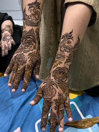 I love how this design combines large, shaded roses on the hands with more delicate floral patterns extending up the arms. It creates a balanced and elegant look for any party.