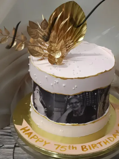 A cake that holds memories. This 75th birthday design features an edible photo strip of cherished moments, topped with elegant gold floral accents. It’s a heartfelt way to celebrate a life well-lived.