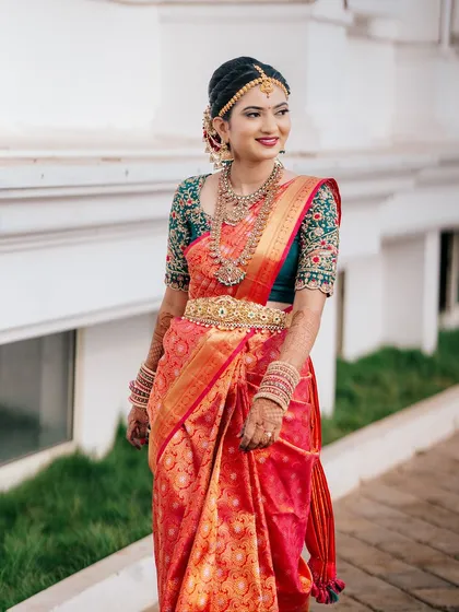 Rakshita walking with a confident smile, showcasing her complete bridal look in motion.