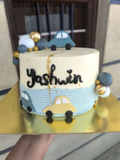 A cutesy cartoon car cake for a little one's celebration. While I don't do hyper-realistic vehicles, I love making these playful versions with adorable fondant cars and decorative baubles.