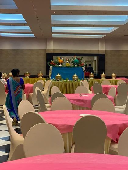 The dining hall at CMA Palace set up for a wedding reception. The vibrant pink tablecloths and clean white chair covers create a cheerful and welcoming atmosphere for guests before the festivities begin.