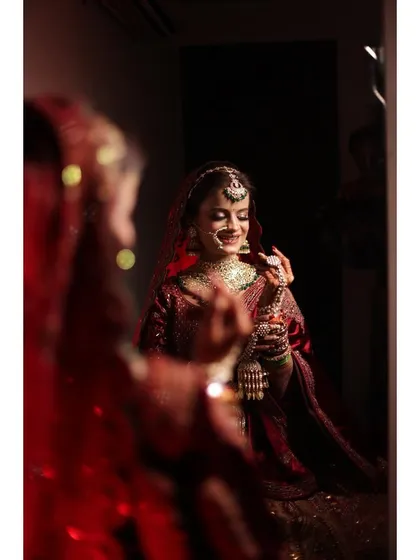 A beautiful bridal portrait captured in the mirror, reflecting the bride's joy and anticipation on her wedding day.