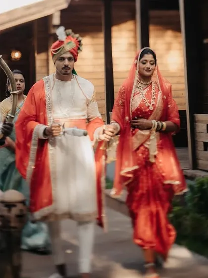 The grand entrance of a royal Maratha couple, accompanied by attendants blowing traditional horns (tutari).