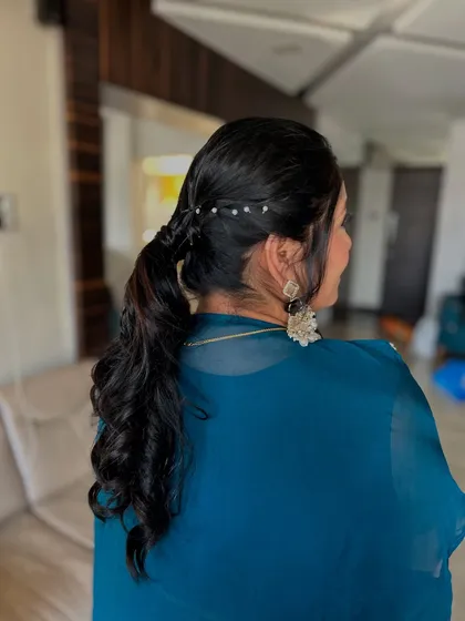 A simple yet elegant curly ponytail. This style is perfect for keeping hair manageable while still looking polished and put-together.