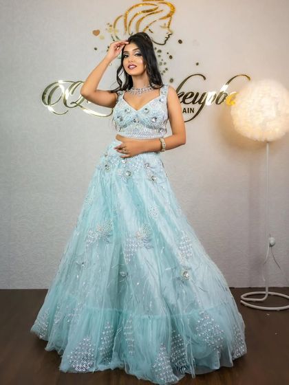 A model posing in the sky-blue lehenga, looking elegant and chic.