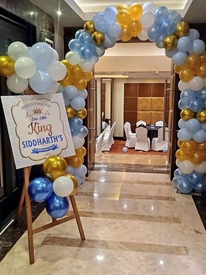 A royal welcome for 'Little King Siddharth' with a blue, white, and gold balloon arch and a personalized sign.