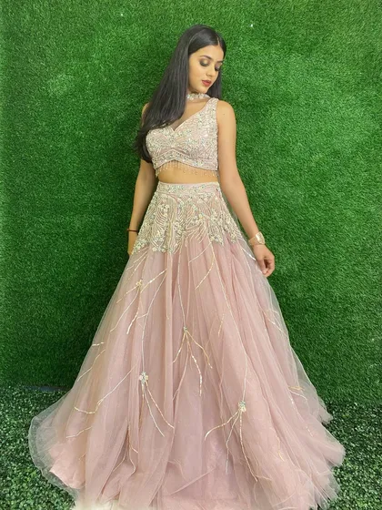 Another view of our pastel pink lehenga, showcasing its A-line skirt and finely detailed blouse. It's a subtle yet stunning choice.