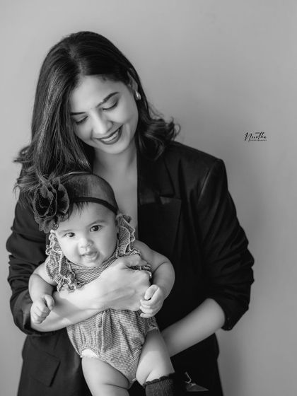 A black and white portrait of a mother holding her baby.