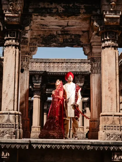 A wide portrait capturing the couple on a balcony of the stepwell. This shot emphasizes the grandeur and intricate design of the heritage location, making them look like true royalty.