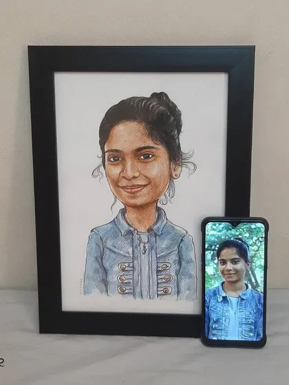 The final handmade caricature, framed and placed next to the original photo for comparison.