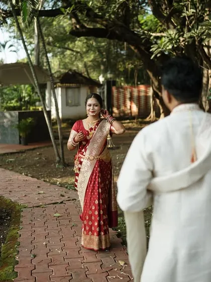 The "first look" moment. The groom's back is to the camera as he sees his bride for the first time, a composition that builds anticipation and focuses on her reaction.